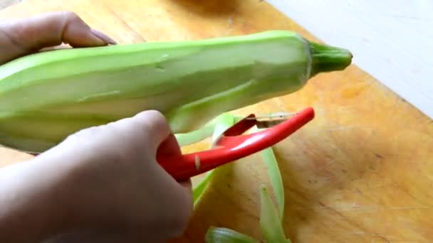 Una ragazza sbuccia e taglia una zucchina per fare stufato, insalata o zuppa. vegetariano, cibo crudo, dieta, perdita di peso — Video Stock