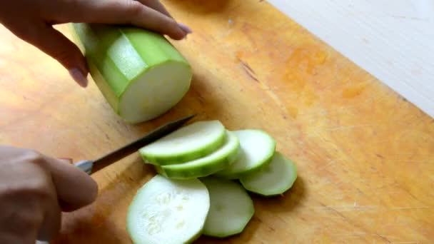 En flicka skalar och skär en zucchini för att göra gryta, sallad eller soppa. vegetarisk, raw food, kost, viktminskning — Stockvideo