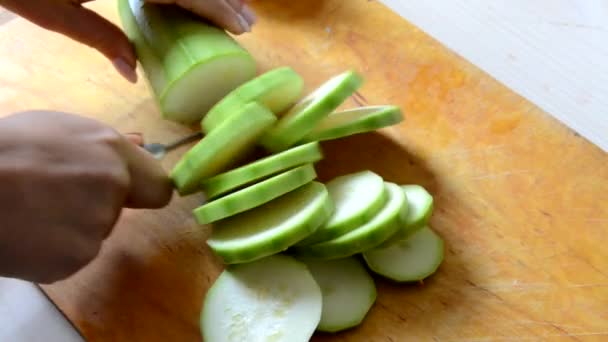 En flicka skalar och skär en zucchini för att göra gryta, sallad eller soppa. vegetarisk, raw food, kost, viktminskning — Stockvideo