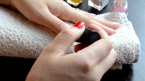 Маникюр - красивые ухоженные женщины ногти с красным лаком для ногтей на мягком белом полотенце. красный и перламутровый лак, выбирает ногти — стоковое видео