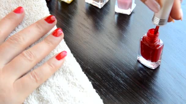 Manicura: hermosas uñas de mujer cuidadas con esmalte de uñas rojo sobre una toalla blanca suave. barniz rojo y nacarado, selecciona uñas — Vídeo de stock