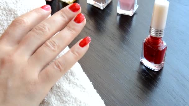 Manicura: hermosas uñas de mujer cuidadas con esmalte de uñas rojo sobre una toalla blanca suave. barniz rojo y nacarado, selecciona uñas — Vídeo de stock