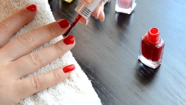 Manikúra - krásné manikúra ženské nehty s červeným lakem na nehty na měkkém bílém ručníku. červený a perleťový lak, vybírá nehty — Stock video