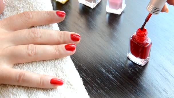 Manicura: hermosas uñas de mujer cuidadas con esmalte de uñas rojo sobre una toalla blanca suave. barniz rojo y nacarado, selecciona uñas — Vídeo de stock