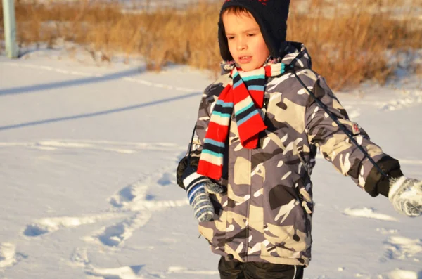 Słodkie mały chłopiec, dziecko w zimie ubrania spaceru pod śniegiem, zabawy ze śniegiem szczęśliwy — Zdjęcie stockowe