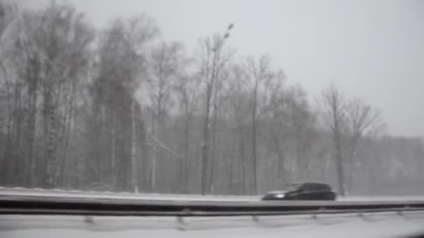 Winterweg zonder focus. De auto staat op de ijzige winterweg. Rijden door het besneeuwde bos. — Stockvideo