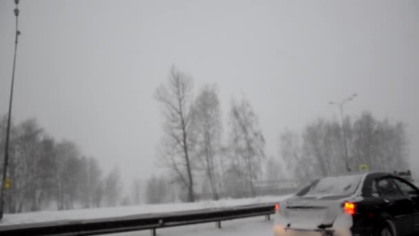 Estrada de inverno sem foco. O carro está na estrada gelada do inverno. Condução através da floresta coberta de neve. — Vídeo de Stock