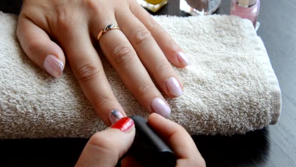 Manicure - Vackra manikyrerade kvinnor naglar med röda nagellack på mjuk vit handduk. röd och pärlemorskimrande lack, väljer spik — Stockvideo