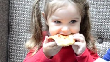 Pizza yiyen güzel bir kız, kafede oturup pizza yiyen tatlı bir kız. Annem yanında oturuyor, pizza yemesine yardım ediyor..