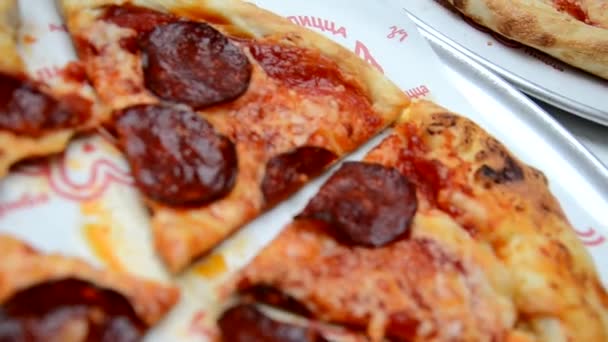 Hermosa chica comiendo pizza, niña linda sentada en un café y comiendo pizza. Mamá está sentada a su lado, ayudándola a comer pizza. . — Vídeos de Stock