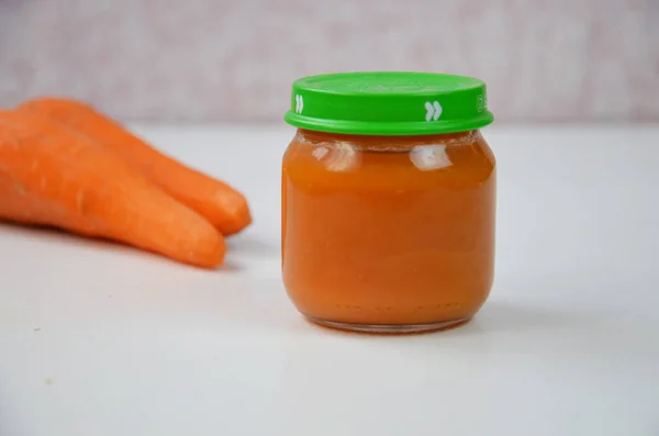 Makanan bayi, bayi ditumbuk dalam botol kaca, irisan wortel — Stok Foto
