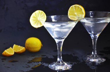 Siyah arka planda iki bardak limonlu martini. Bir barda iki bardak martini kokteyli.