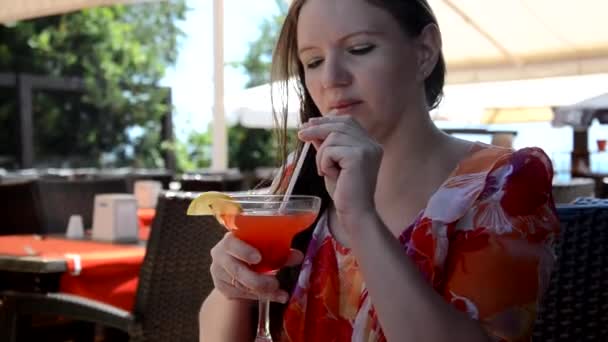 Retrato de una hermosa joven disfrutando de una bebida, chica bonita bebiendo jugo de plátano en la terraza de la cafetería — Vídeo de stock