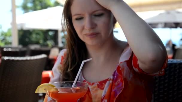 Retrato de una hermosa joven disfrutando de una bebida, chica bonita bebiendo jugo de plátano en la terraza de la cafetería — Vídeo de stock
