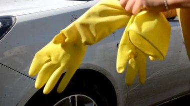 Sarı eldivenli El 'in yakın çekimi bez yıkamalı çeşitli makine parçaları fırçalayan beyaz araba