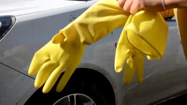 Primer plano de la mano en guantes amarillos con un trapo lavar varias piezas de la máquina Cepillo Lavado coche blanco — Vídeo de stock