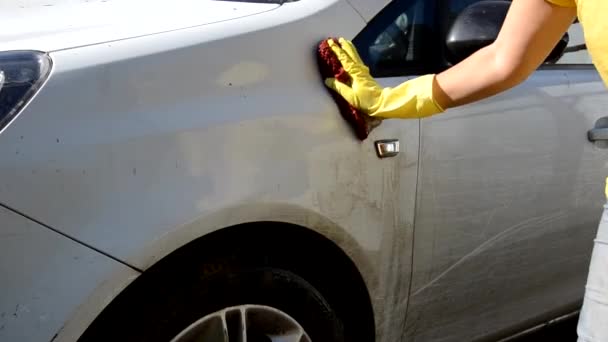 Primer plano de la mano en guantes amarillos con un trapo lavar varias piezas de la máquina Cepillo Lavado coche blanco — Vídeos de Stock