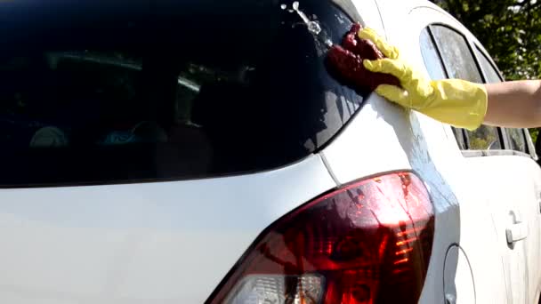 Primer plano de la mano en guantes amarillos con un trapo lavar varias piezas de la máquina Cepillo Lavado coche blanco — Vídeos de Stock