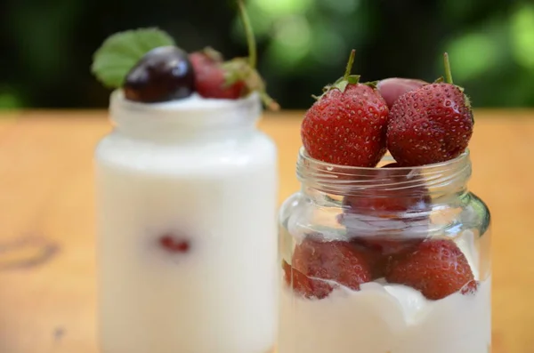 Healthy breakfast home made pudding or yogurt or granola, strawberries, cherry, honeysuckle berry, nuts and yogurt in a bowl. Vegetarian concept food. Top view. pudding or cocktail on the background