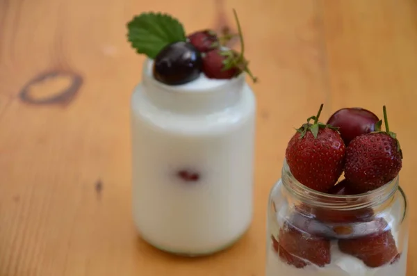 Sağlıklı kahvaltıda puding, yoğurt, granola, çilek, kiraz, hanımeli böğürtlen, fındık ve yoğurt yenir. Vejetaryen konsept yiyecekler. Üst Manzara. Arka planda puding ya da kokteyl — Stok fotoğraf