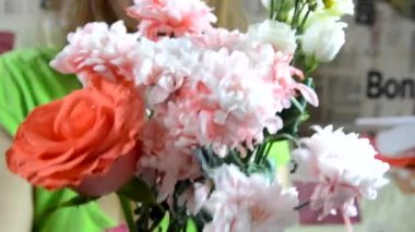 Güzel bir buket parlak ve renkli çiçek, kızların ellerinde.