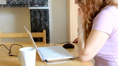 Ciddi genç kadın serbest çalışan, dizüstü bilgisayarında e-posta yazan, internetten bilgisayar kullanan, telefon, kahve ya da çay içen, internet işiyle meşgul olan kadın kullanıcı.
