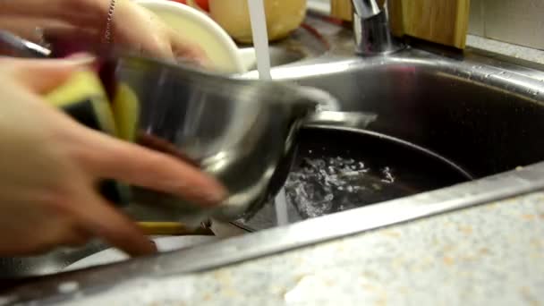 Las manos de la mujer enjuagan la placa en el fregadero de la cocina, haciendo las tareas en casa con detergente de plato de esponja. Rutina de lavado de platos, cámara estática . — Vídeos de Stock