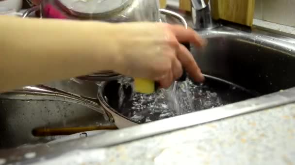 Las manos de la mujer enjuagan la placa en el fregadero de la cocina, haciendo las tareas en casa con detergente de plato de esponja. Rutina de lavado de platos, cámara estática . — Vídeos de Stock