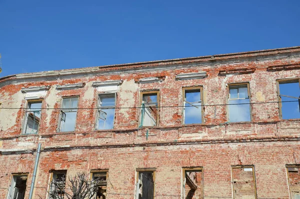 Fachada de tijolo de um edifício antigo abandonado com janelas. — Fotografia de Stock