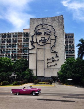 Küba, La Habana - 2 Temmuz 2016. Che Guevara ile muhteşem bir eski pembe Araba, 2 Temmuz 2016 üzerinde La Habana Küba'da devrim meydanında portresi ile bina. 