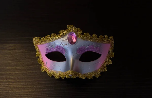 Maschera di Carnevale su sfondo nero in legno Foto Stock