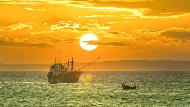 Gün batımında balıkçı köyü ve geleneksel Vietnam balıkçı tekneleri