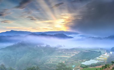 Sis, dramatik bulutlar gökyüzünde bir sürü tepe üzerinde şafak