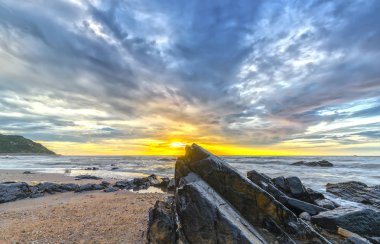 Parlak renkli bulutlar ile sahilde şafak,