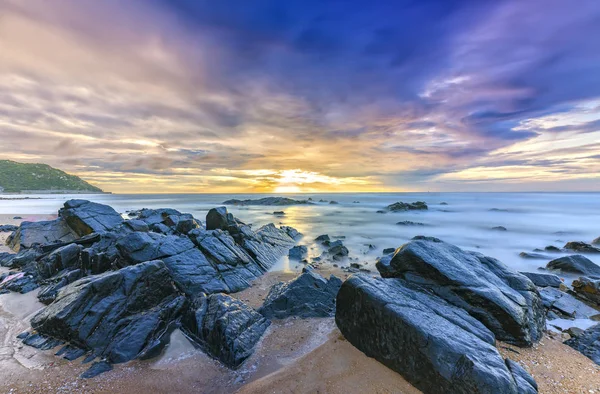 Parlak renkli bulutlar ile sahilde şafak,