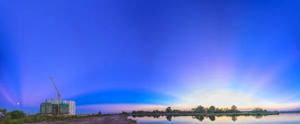 Raios de sol ao longo do rio quando o sol se põe para o horizonte — Fotografia de Stock