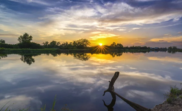 Ηλιοβασίλεμα κατά μήκος του ποταμού καθώς ο ήλιος κάτω ΧΩΡΙΖΩ — Φωτογραφία Αρχείου