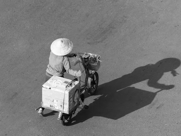 Gatuförsäljare promenader med skugga faller länge på väg — Stockfoto