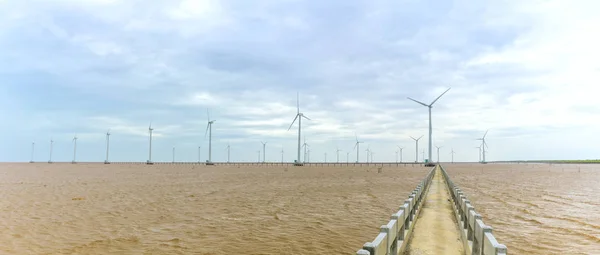 Clean energy, wind power plant with a pathway to the giant wind turbines at sea
