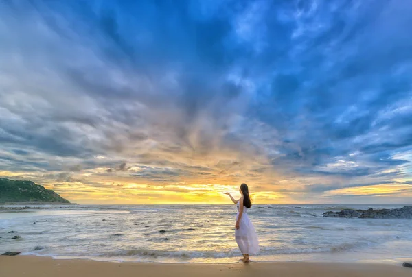 Lonely young woman stands alone on the beach — Stock Photo, Image