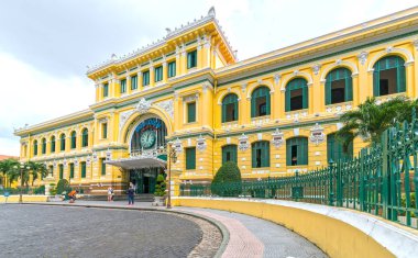Tourists visit outside Saigon Central Post Office Architecture.  clipart