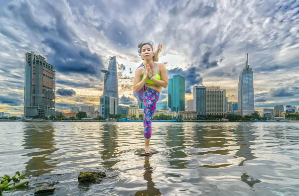 Jovem mulher atraente na perna atrás do pescoço pose — Fotografia de Stock