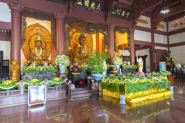 Boeddhistische standbeeld in tempel versierd lichten, kleurrijke bloemen op Boeddha's verjaardag. — Stockfoto