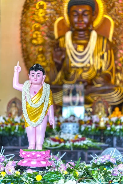 Estátua budista em luzes decoradas no templo, flores coloridas no aniversário de Buda . — Fotografia de Stock