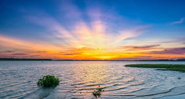 Renkli günbatımı güneş yavaş yavaş yukarı doğru çok güzel gökyüzü güzel ışınları oluşturmak için nehrin