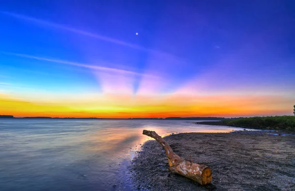 Rays of sunset along river when the sun goes down to the horizon shining the sunshine into the dramatic sky. This rare moment is admired in the sky at the end of day.