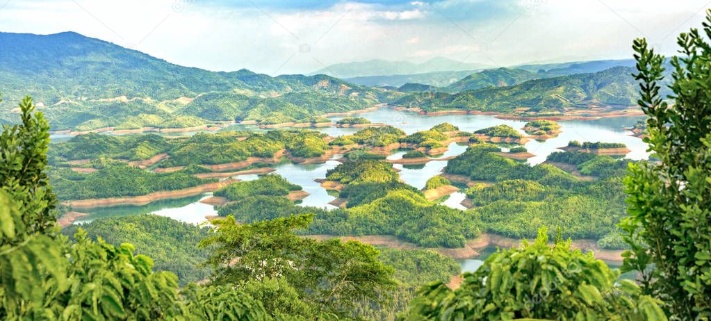 Ta Dung lake in the summer afternoon when the sun shines down on the lake and the trees on the small island paradise. This is the reservoir for hydropower in Dac Nong, Vietnam.