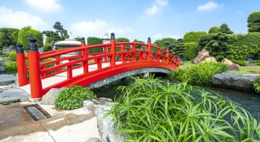 Parktaki kırmızı köprü Japon taş bahçeleri bahçe aksanları için canlı kültür Japonya 'yı doğada temsil ediyor.