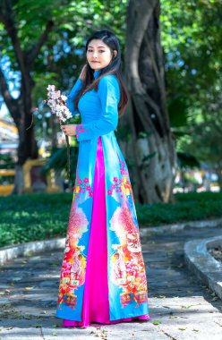 Ho Chi Minh City, Vietnam - 15 Aralık 2019: Geleneksel uzun elbiseli Vietnamlı kız ya da bahar motifli Ao Dai gençliği de Ho Chi Minh City, Vietnam 'da zamansız olarak ifade ediyor