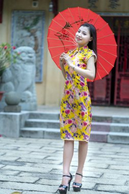 Ho Chi Minh Şehri, Vietnam - 3 Ağustos 2019: Vietnam 'da Ho Chi Minh City, Vietnam' da güzel bir sabah tapınağında büyüleyici bir şekilde poz veren Vietnamlı geleneksel Cheongsam giyim kızı